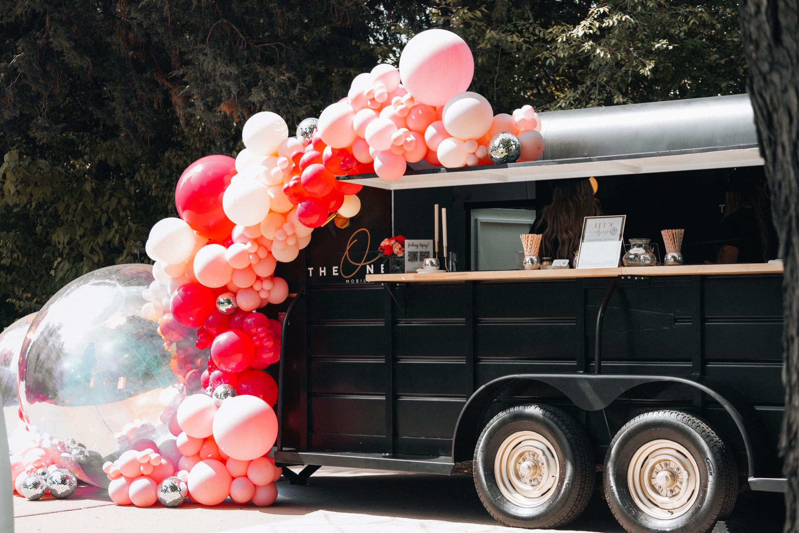 The One Mobile Bar — vintage horse-trailer bar with balloon garland